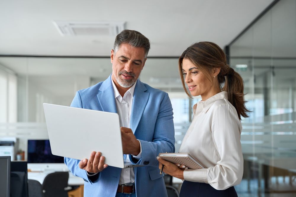 Make and female colleagues looking at the laptop