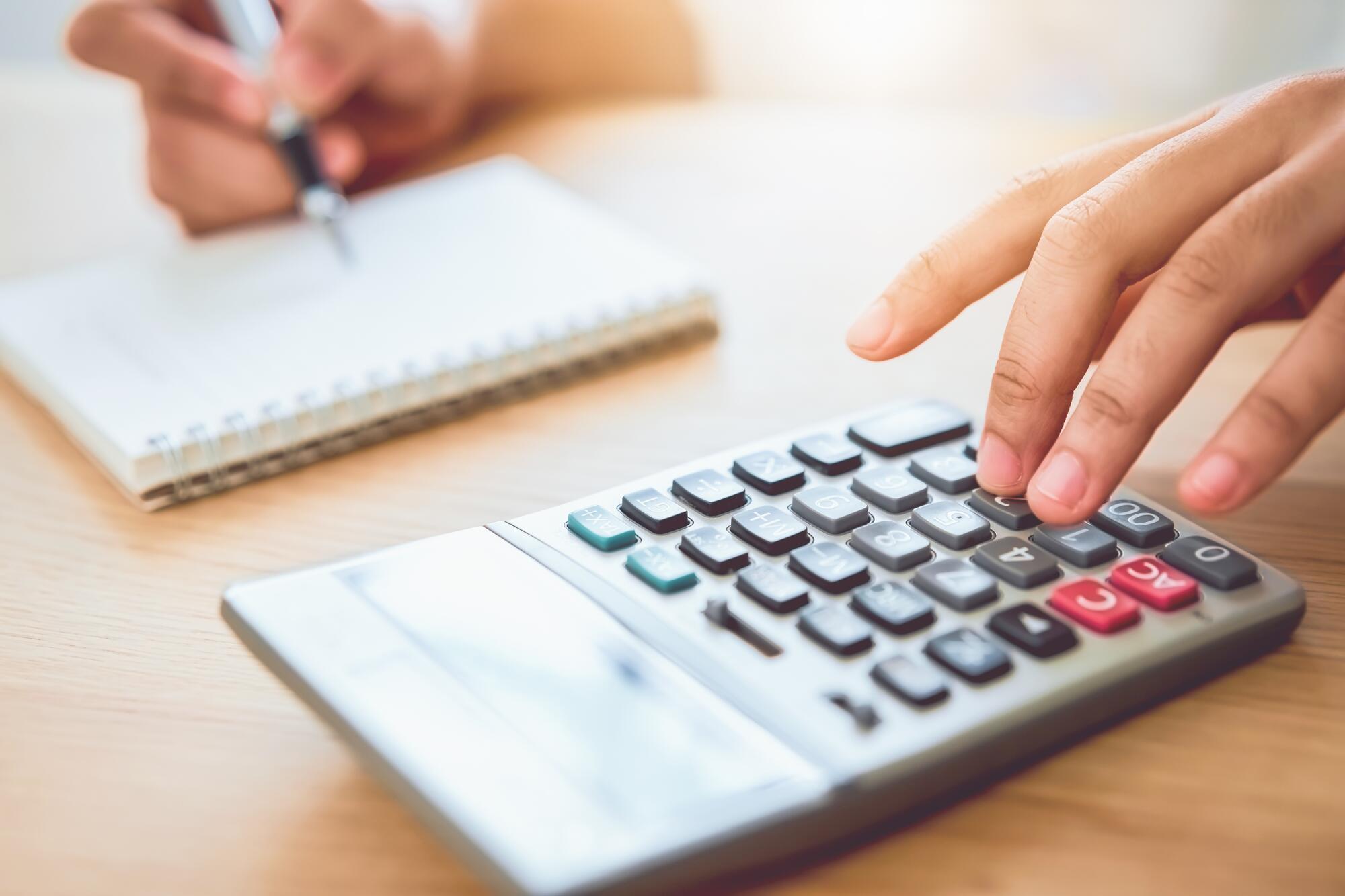 woman_holding_and_press_calculator_to_calculate_income_expenses_and_plans_for_spending_money_on_home_office